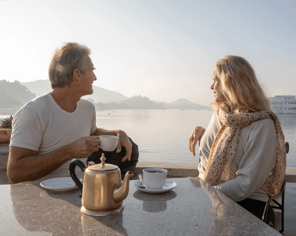 Couple enjoying tea by a lakeside view.