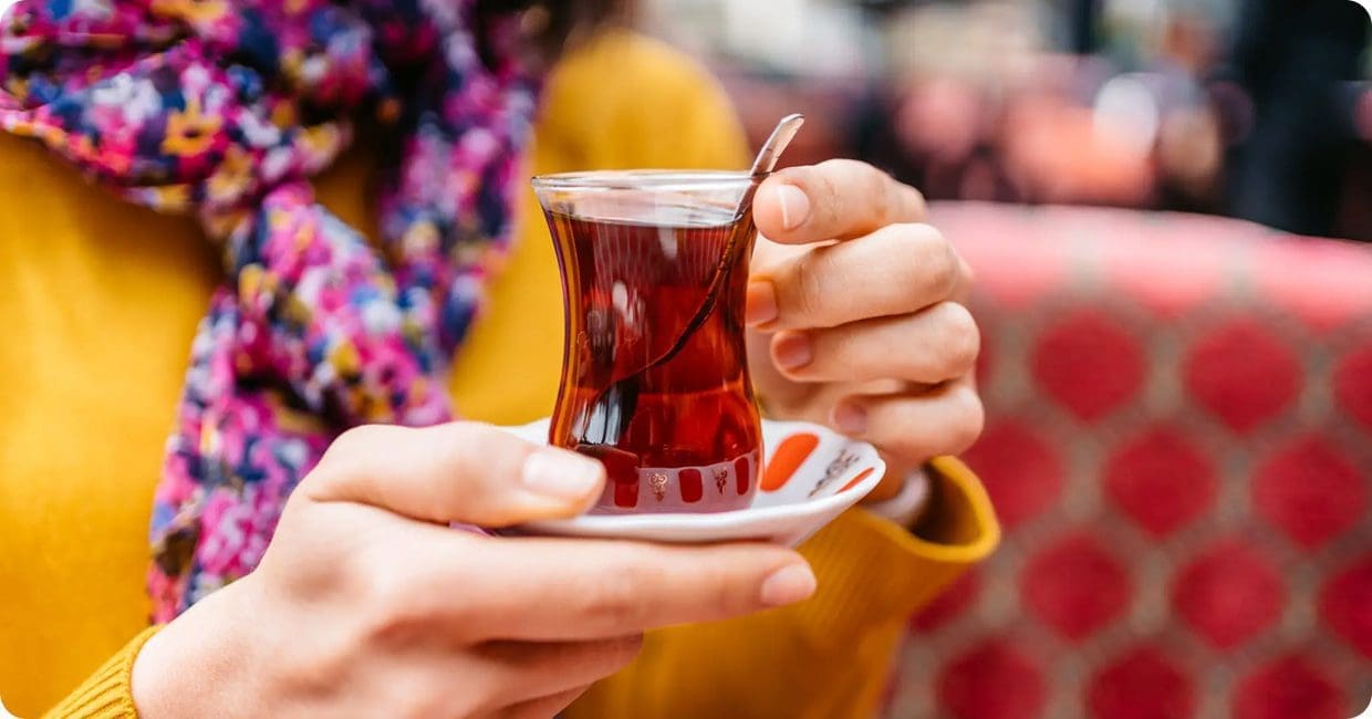 Person holding a glass of tea.