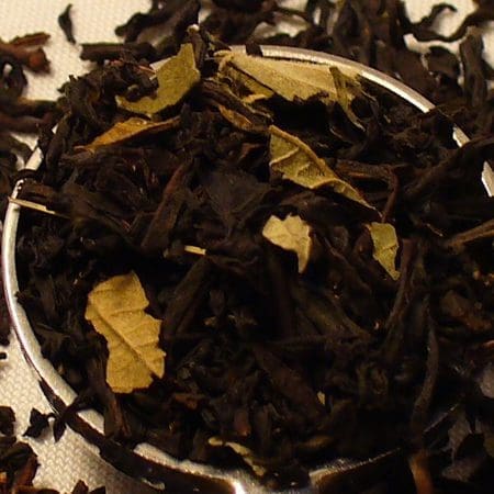Close-up of loose black tea leaves with yellow flower petals.