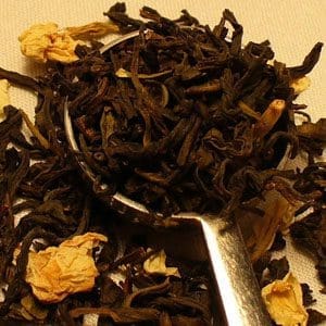 Close-up of dried tea leaves with yellow flower petals.
