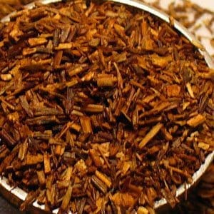Close-up of dried rooibos tea leaves in a container.