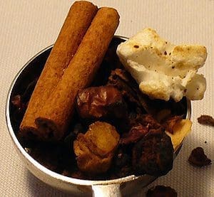 Cinnamon sticks and spices in a spoon.