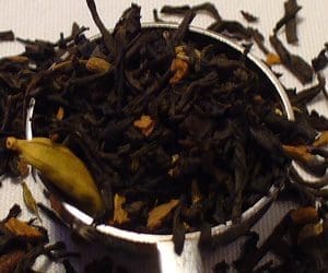 Loose black tea leaves in metal infuser