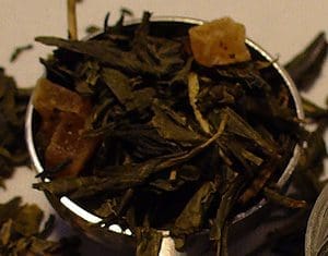 Close-up of loose black tea leaves with brown sugar chunks.