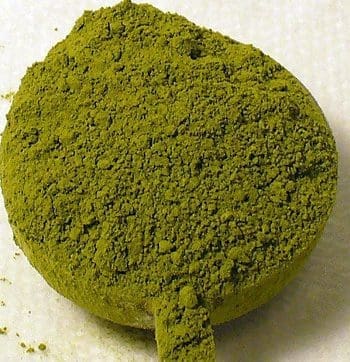 Compressed green powder on white background.
