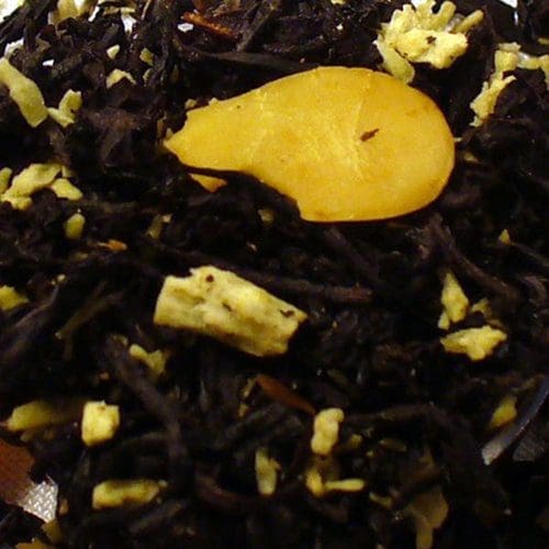 Close-up of loose black tea leaves with a slice of dried fruit.